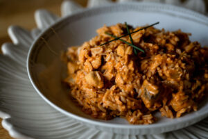 A tasty chicken and mushroom stroganoff served in a white bowl with chives on top.